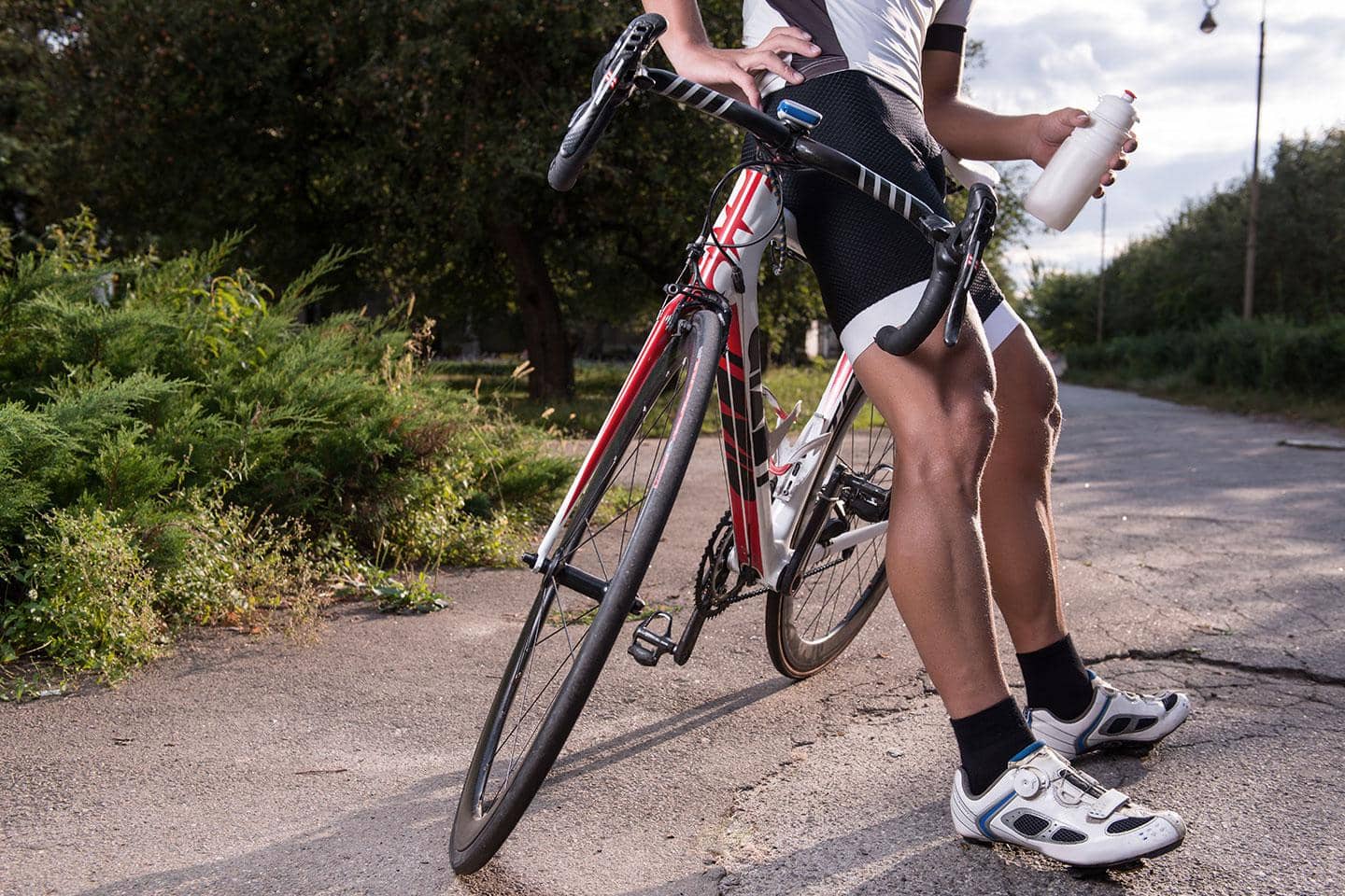 Mand læner sig op af cykel på landevej