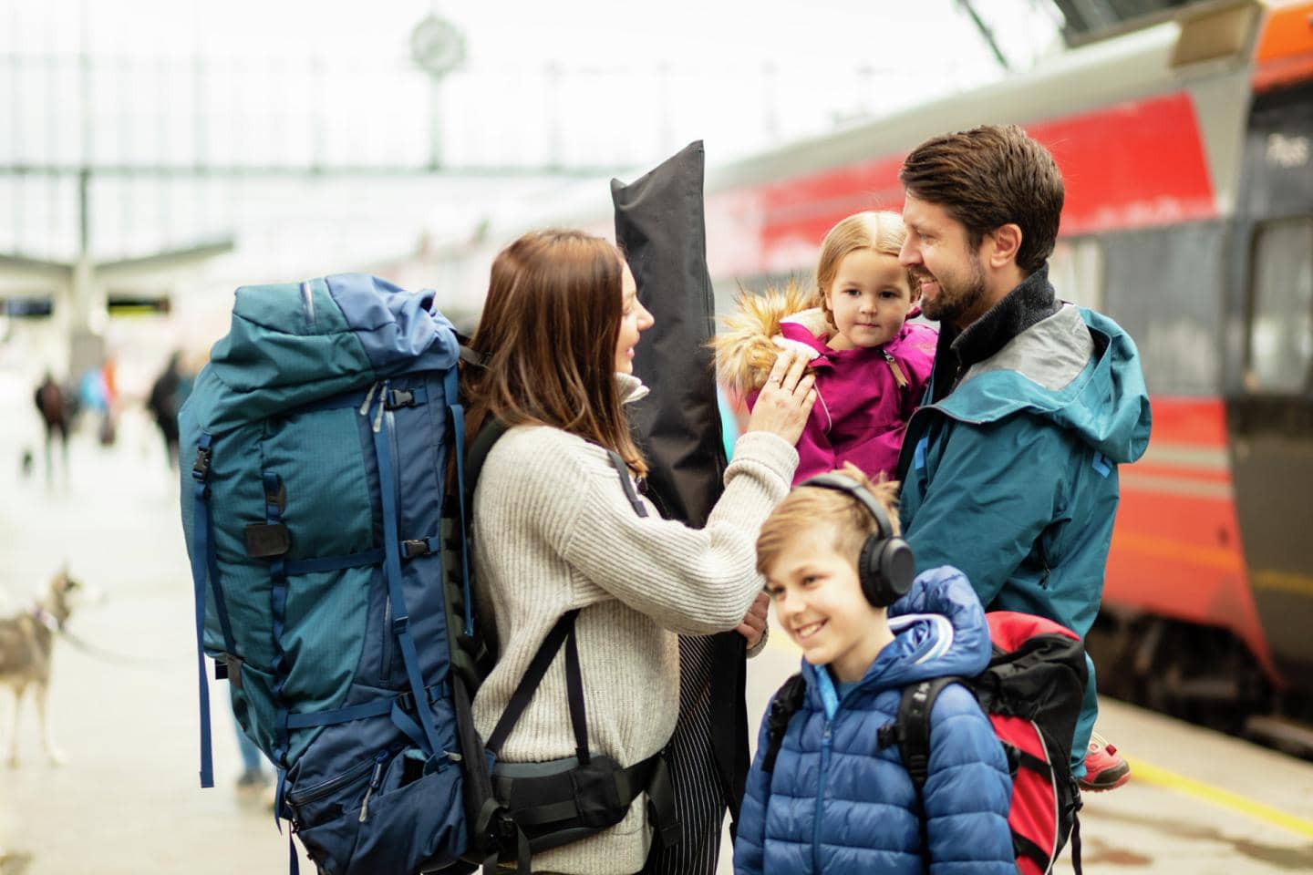Børnefamilie står sammen foran et tog