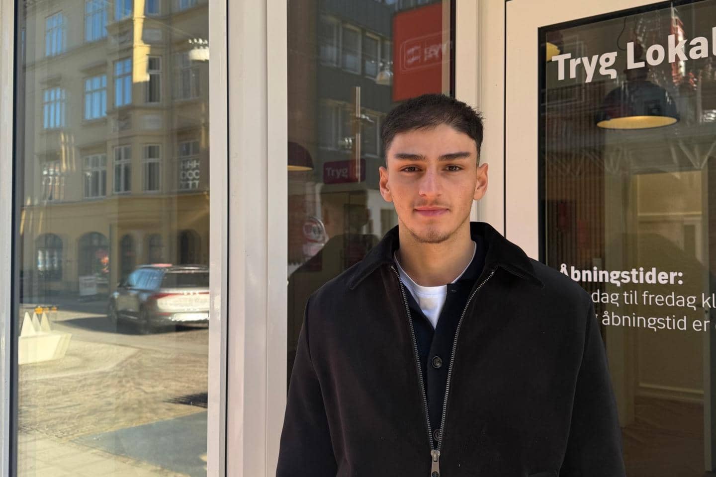 Mand står foran butiksdør