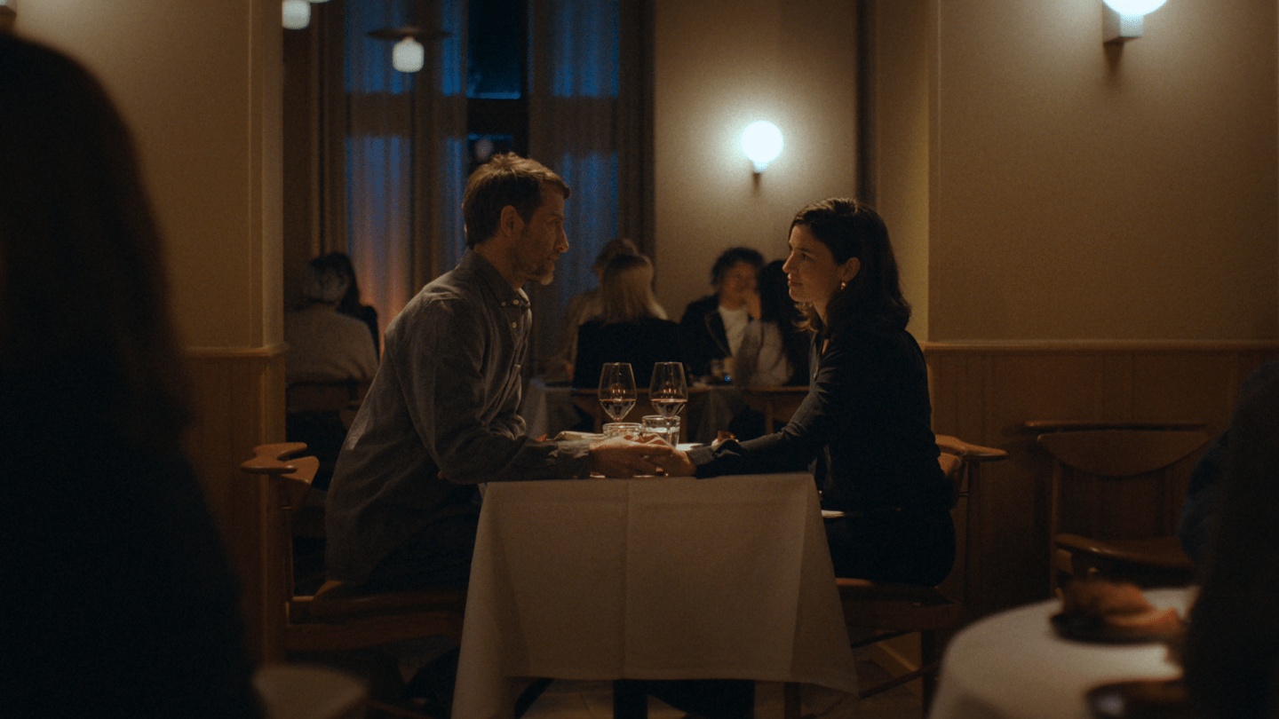 Par sidder ved bord i restaurant, fotografi