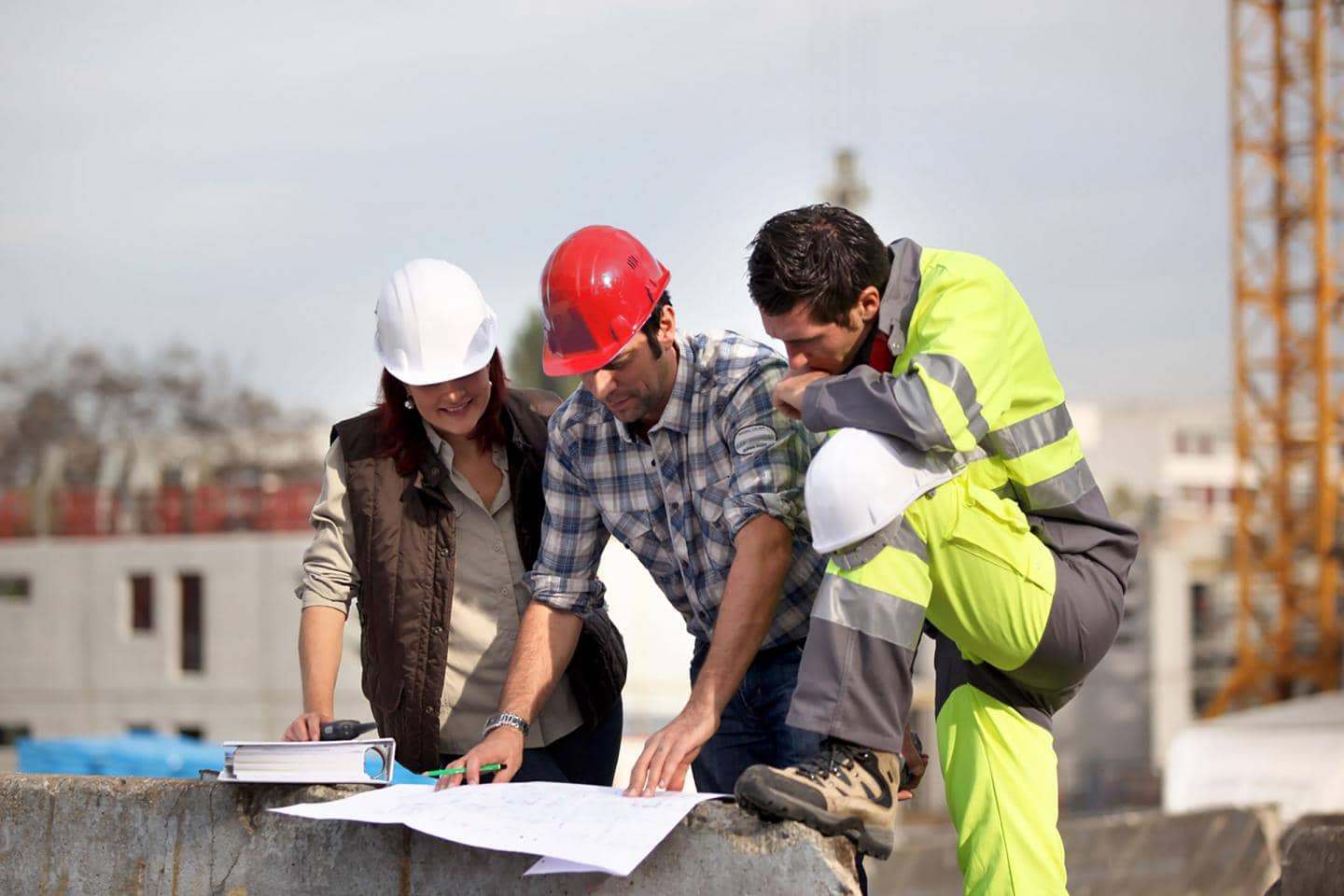 Entrepriseforsikring, bygningskonstruktør, entreprenør og håndværker ser på bygningstegning
