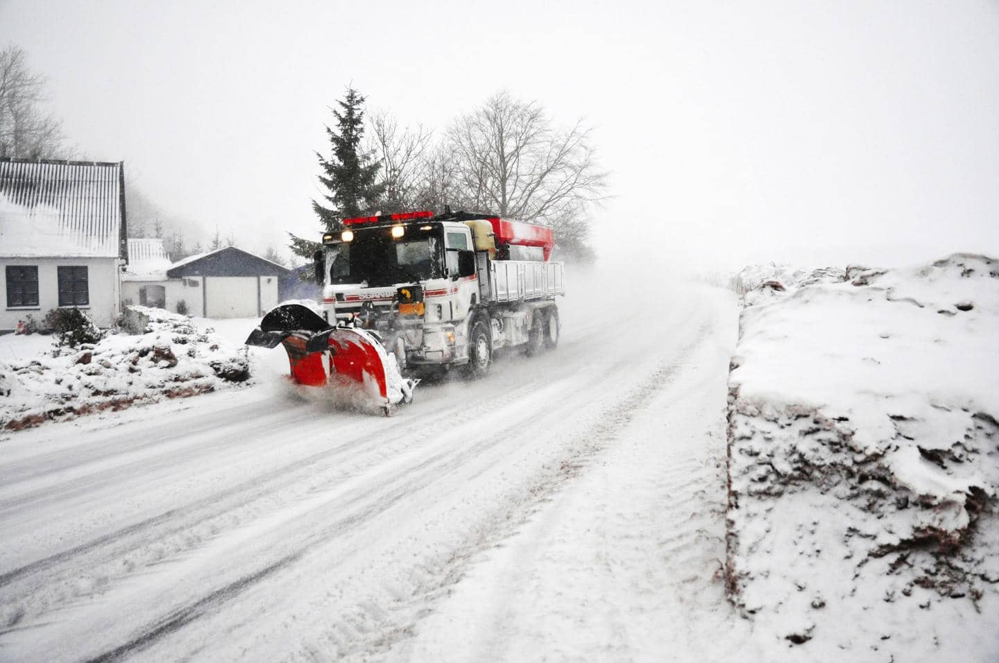 Forbyg vejrskader, traktor kører på vej i ekstremt snevejr