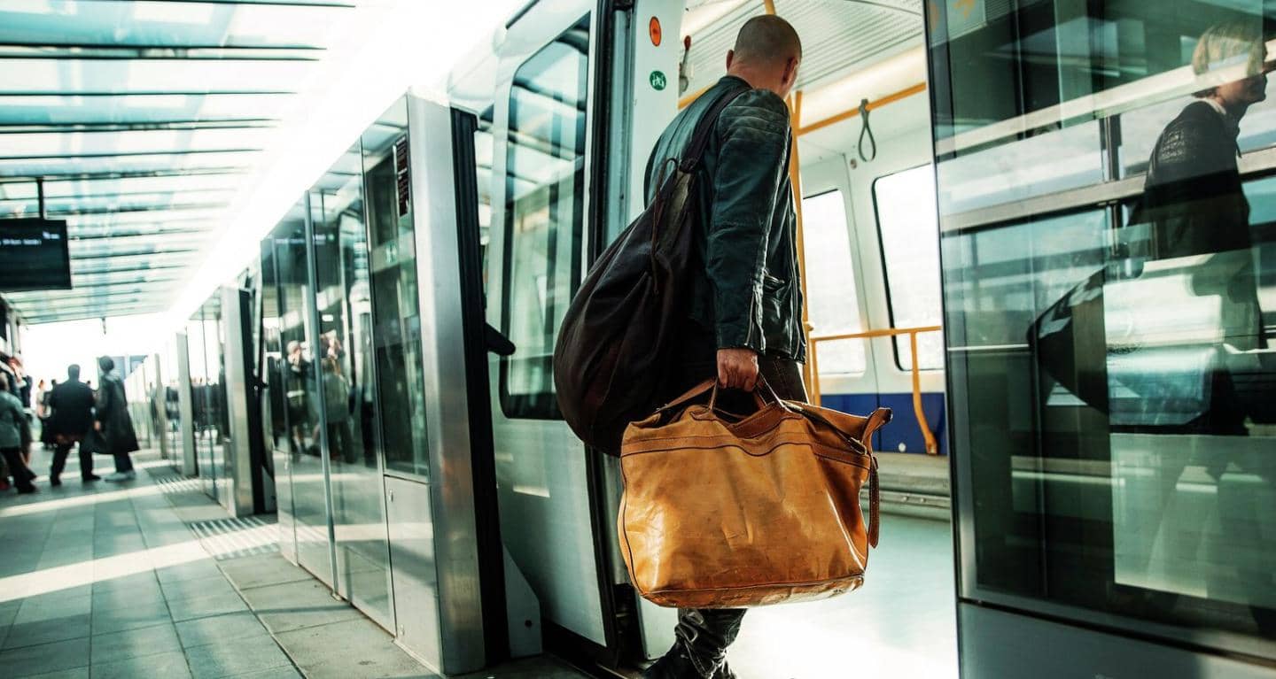 Mand går ind i metro med rejsetaske